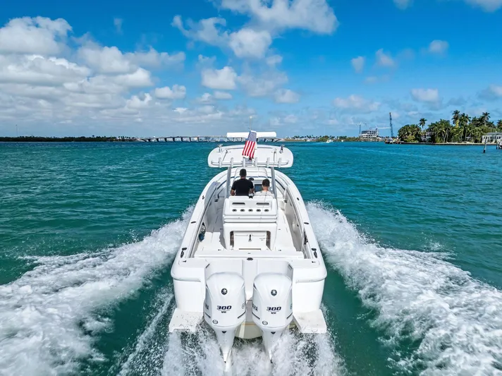 Double Trouble Yacht Photos Pics Intrepid 327 Center Console 2017 boat cruising on clear blue water under a sunny sky.