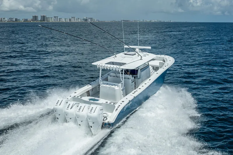  Yacht Photos Pics 2025 Yellowfin 42 Offshore boat cruising on open ocean near city skyline.