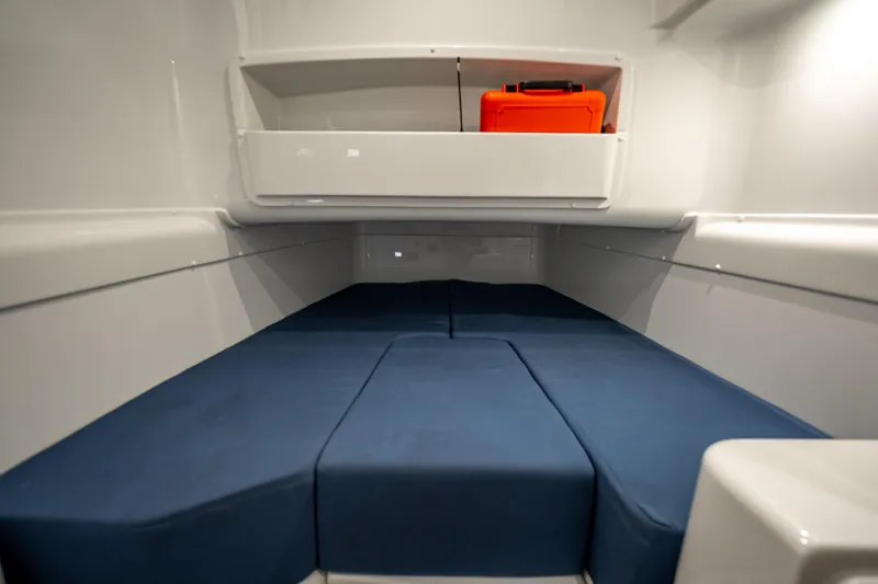 Yacht Photos Pics 2025 Yellowfin 42 Offshore cabin interior with blue cushions and storage shelf.