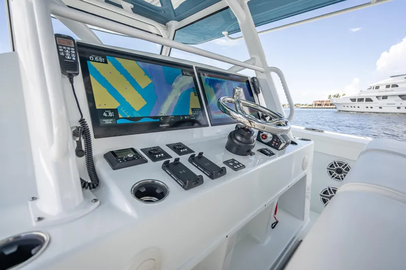  Yacht Photos Pics 2025 Yellowfin 42 Offshore boat dashboard with navigation screens and steering wheel.