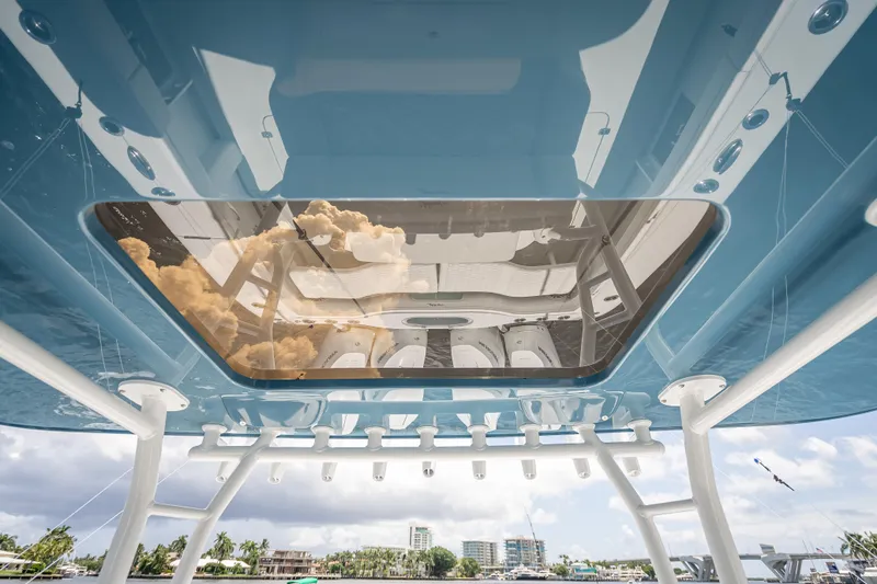  Yacht Photos Pics 2025 Yellowfin 42 Offshore boat with reflective glass roof, showcasing sky and clouds.