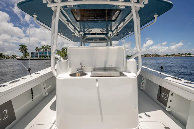  Yacht Photos Pics 2025 Yellowfin 42 Offshore boat interior with sink and grill, under blue sky.