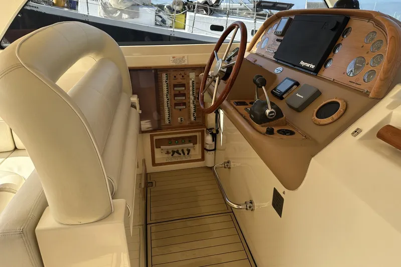 Pallavisino Yacht Photos Pics Helm of 2007 Mochi Craft 44 Dolphin yacht with wooden steering wheel and navigation controls.