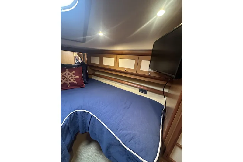 Pallavisino Yacht Photos Pics Cozy cabin interior of 2007 Mochi Craft 44 Dolphin with blue bedding and nautical decor.