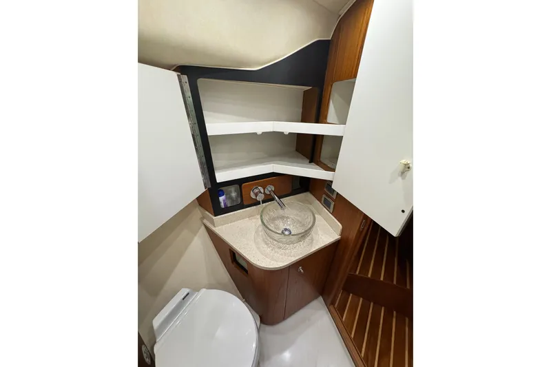  Yacht Photos Pics 2007 Tiara 43 yacht bathroom with modern sink, toilet, and wooden cabinetry.