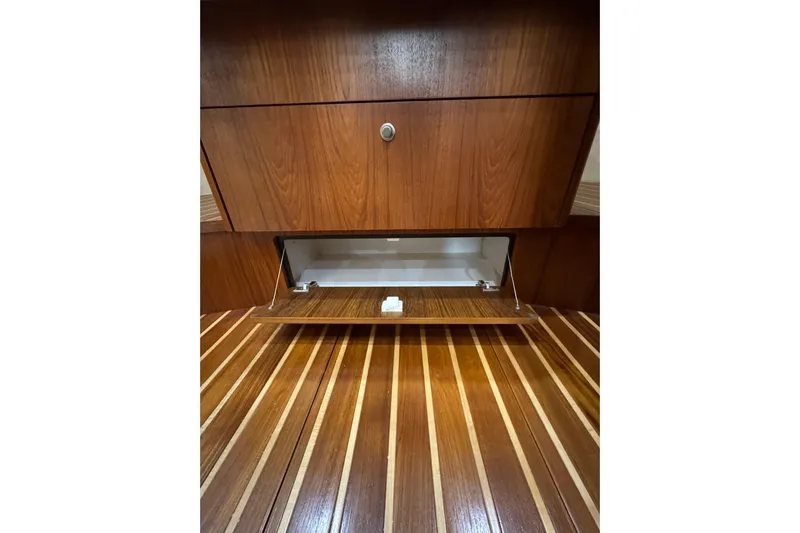  Yacht Photos Pics Wooden interior storage compartment in 2007 Tiara 43 yacht, featuring open cabinet and striped flooring.