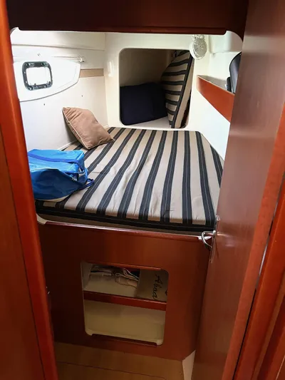 Ikati Yacht Photos Pics Cozy cabin interior of 2011 Leopard 39 yacht with striped bedding and wooden finish.
