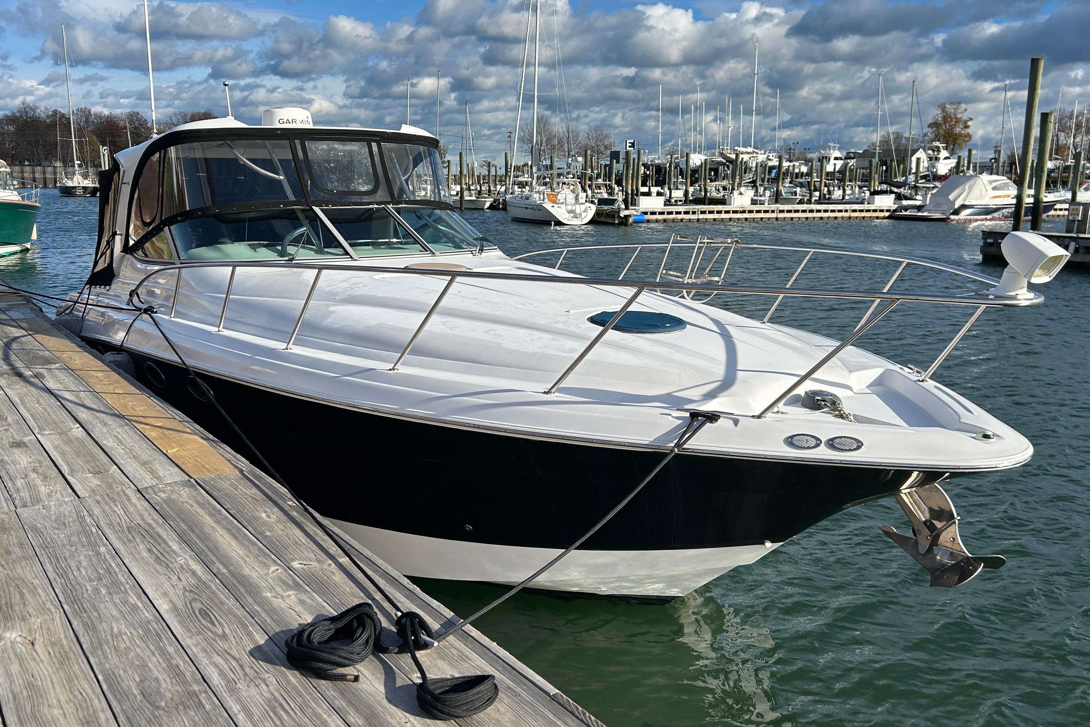 2007 Larson 370 Cabrio boat docked at marina under cloudy sky.