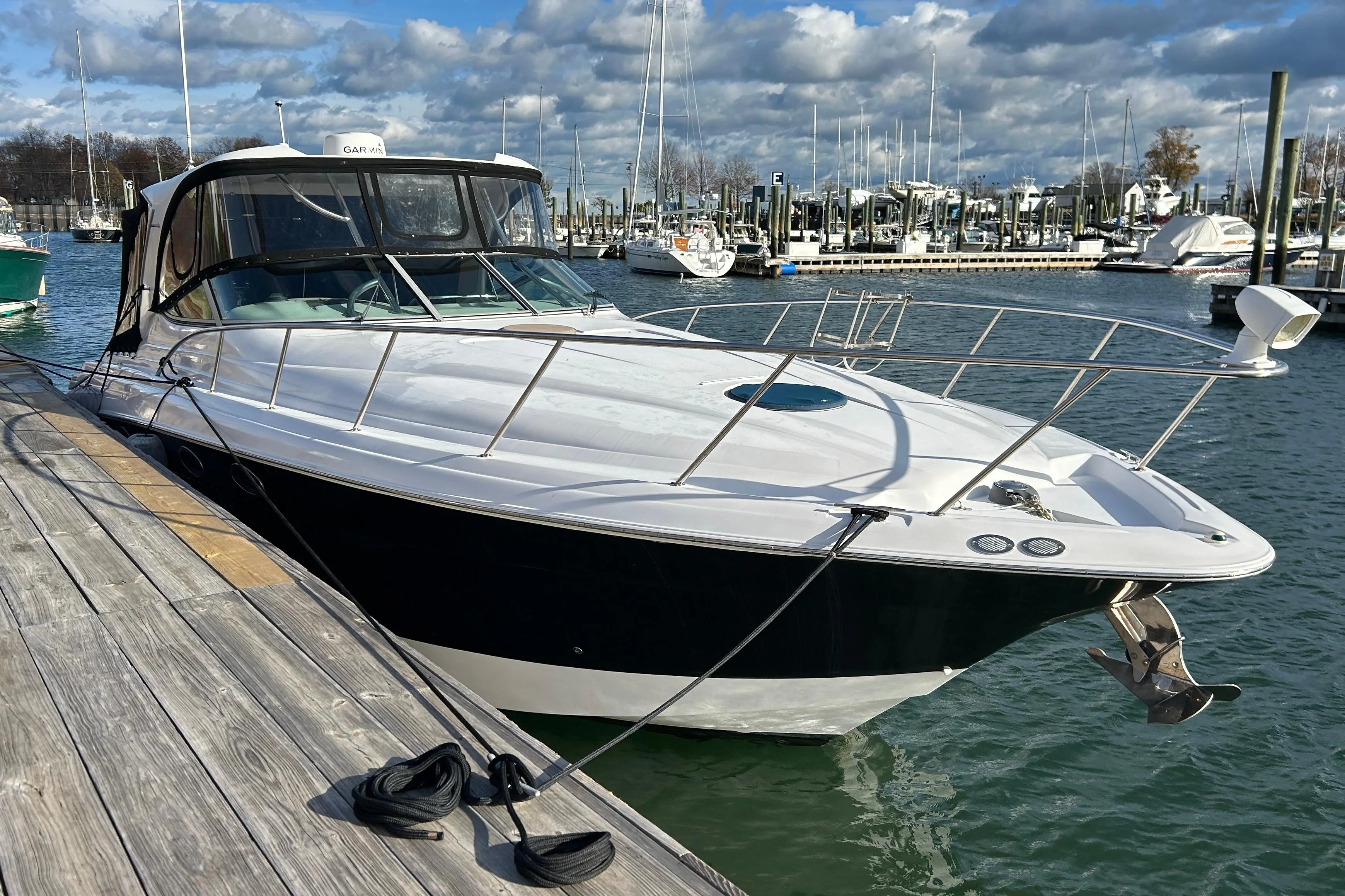 2007 Larson 370 Cabrio boat docked at marina under cloudy sky.