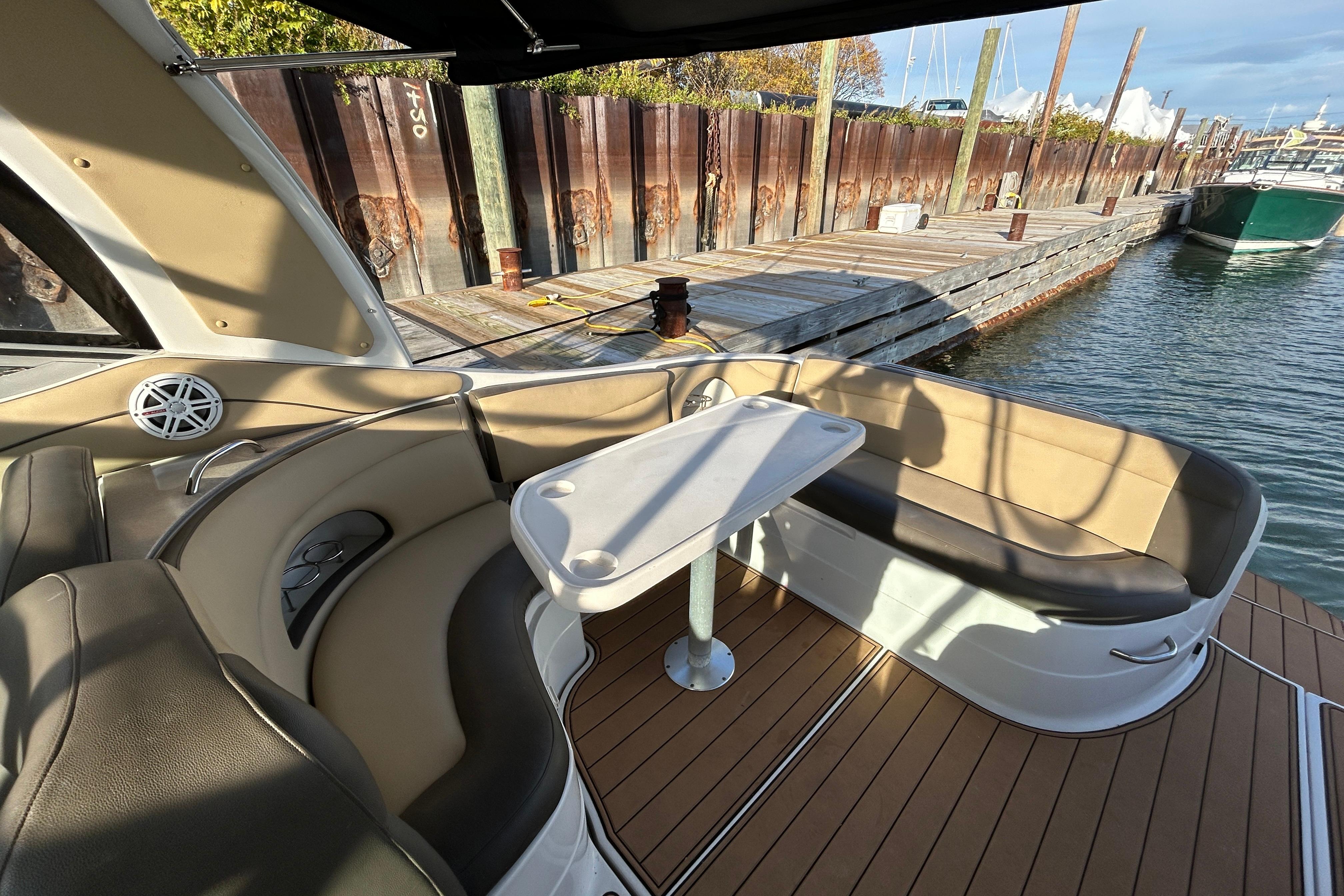 2007 Larson 370 Cabrio boat interior with seating and table at dockside.