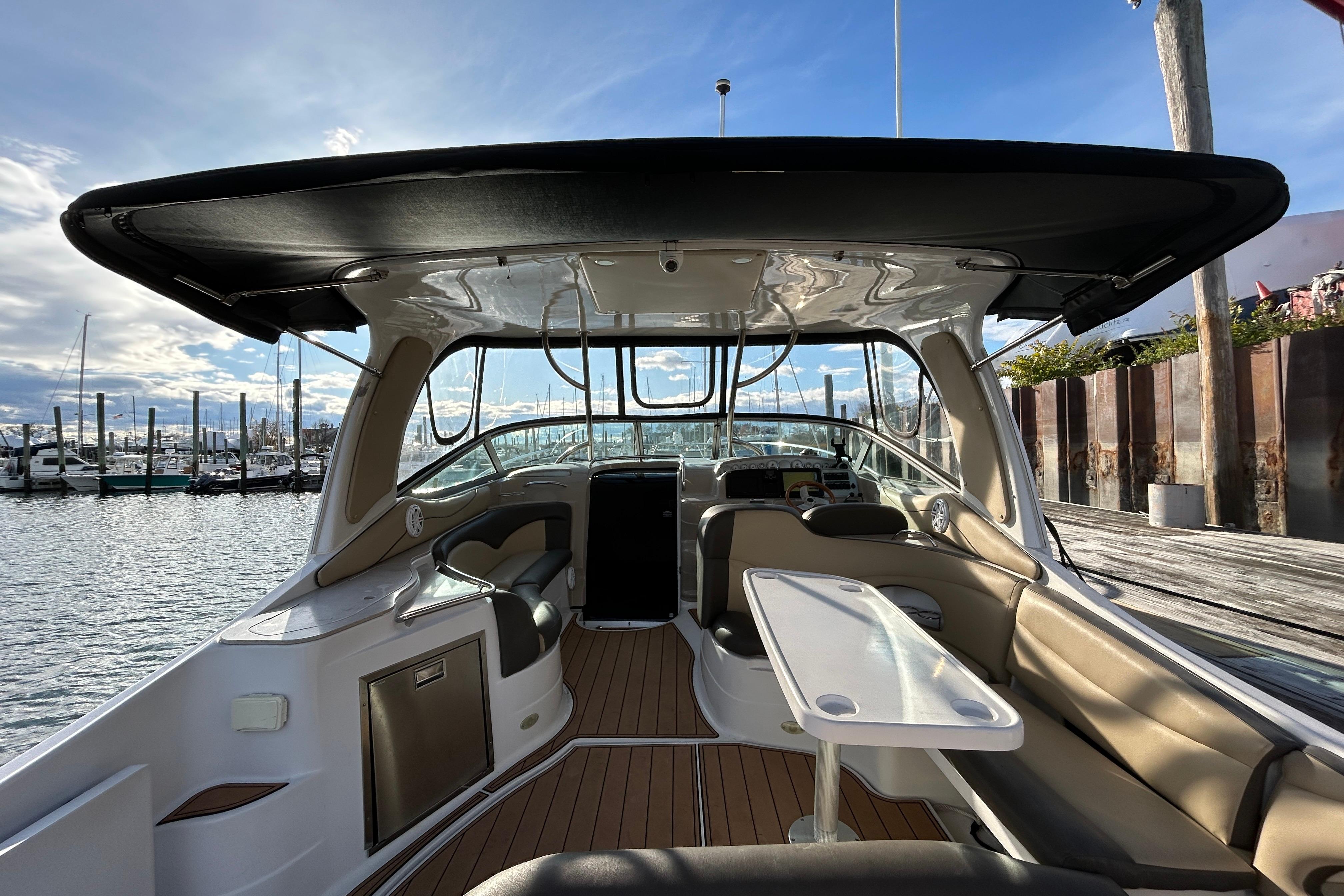 2007 Larson 370 Cabrio boat interior with seating and table, docked at marina.