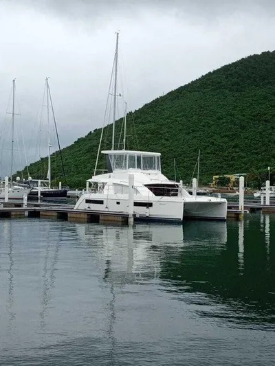 Rockin U Yacht Photos Pics 2020 Leopard 43 Powercat docked in a serene marina with lush green hills.