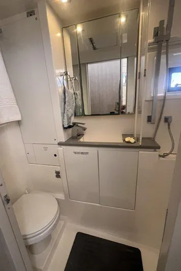 Rockin U Yacht Photos Pics 2020 Leopard 43 Powercat bathroom with modern fixtures, mirror, and storage cabinets.