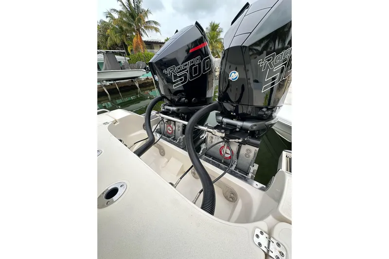  Yacht Photos Pics Twin outboard engines on a 2021 ShearWater 270 Carolina Flare boat, docked near palm trees.