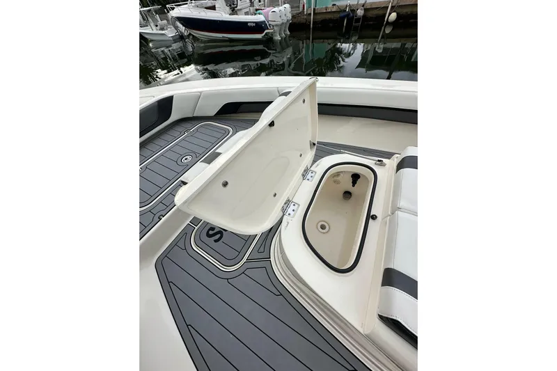  Yacht Photos Pics 2021 ShearWater 270 Carolina Flare boat with open storage compartment, docked by water.