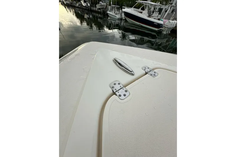  Yacht Photos Pics 2021 ShearWater 270 Carolina Flare boat deck with cleat and hinges, docked by water.