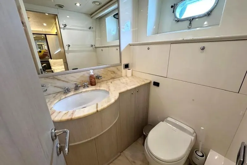 Yacht Photos Pics Luxurious bathroom on 2004 Azimut 100 Jumbo yacht with marble countertop and porthole window.