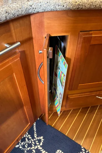 Its A Blast Yacht Photos Pics Wooden cabinet with open door, revealing colorful cutting boards inside, on a Sabre 52 Salon Express.