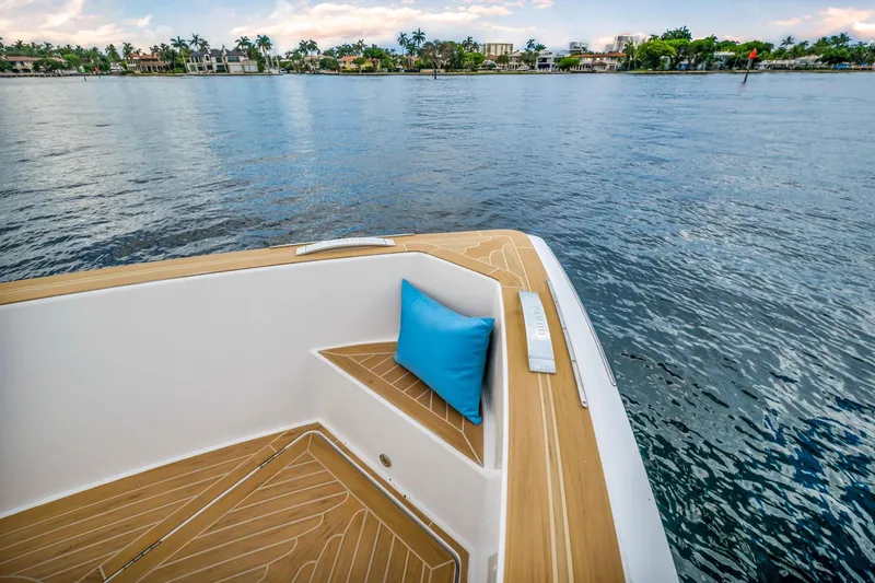 Vector 9 Yacht Photos Pics Pardo Yachts 38 (2021) deck with blue cushion, overlooking serene waterfront.