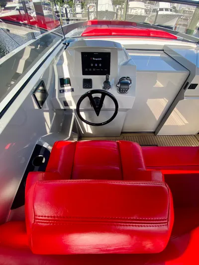Little Rome Yacht Photos Pics Luxurious 2020 Vanquish VQ45 yacht cockpit with red leather seating and modern controls.