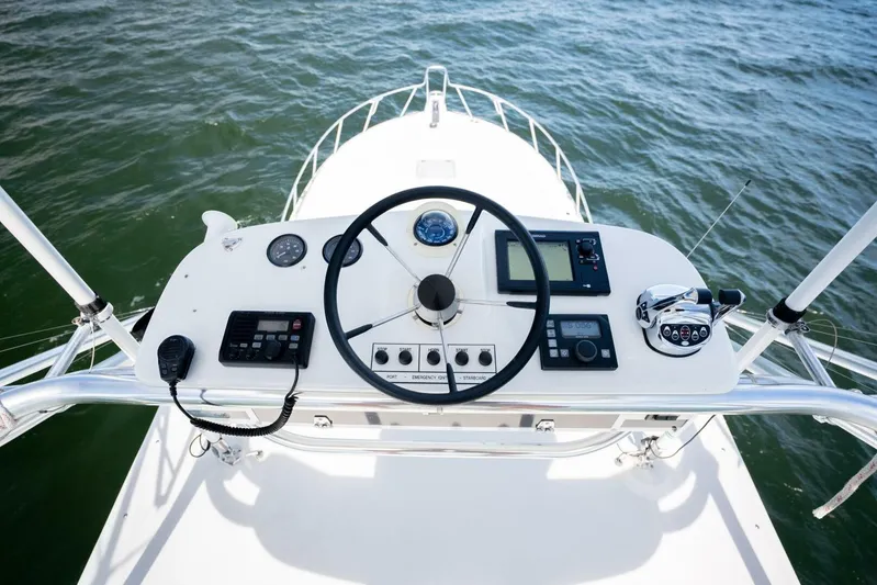 Kat's Meow Yacht Photos Pics Helm of 2004 Cabo 40 Express boat with steering wheel and navigation controls.