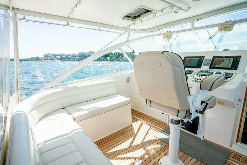 Kat's Meow Yacht Photos Pics 2004 Cabo 40 Express yacht interior with helm, seating, and navigation screens on a sunny day.