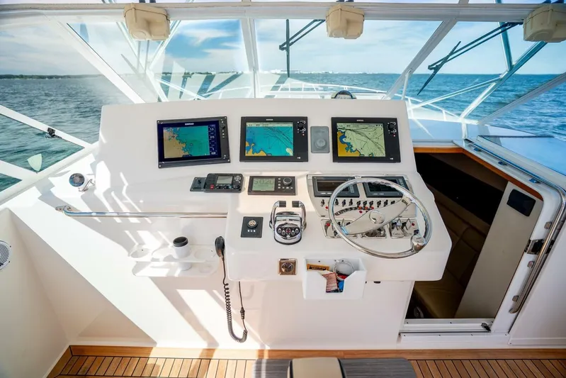 Kat's Meow Yacht Photos Pics Helm of 2004 Cabo 40 Express boat with navigation screens and steering wheel.