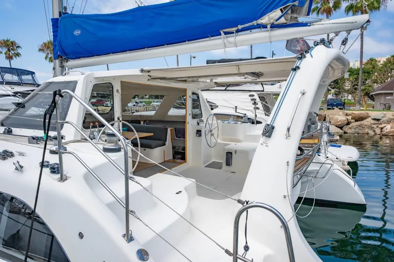 Making Waves Yacht Photos Pics 2006 Seawind 1160 catamaran with blue sail, docked at marina, open cockpit view.