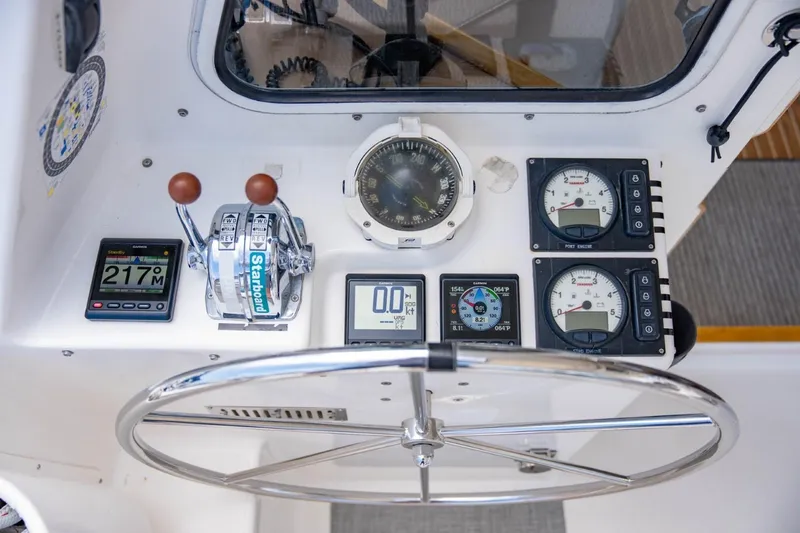 Making Waves Yacht Photos Pics Helm controls of a 2006 Seawind 1160 catamaran with navigation instruments and steering wheel.