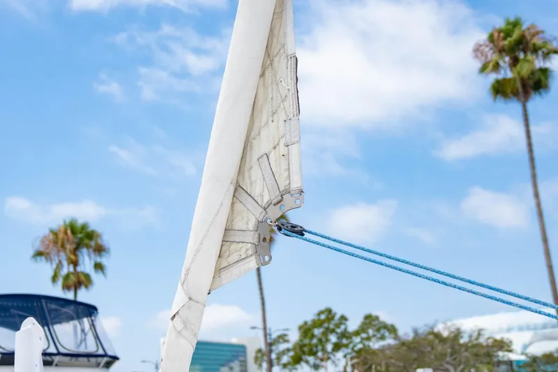 Making Waves Yacht Photos Pics Close-up of a Seawind 1160 sailboat's sail and rigging, 2006 model, with palm trees in background.