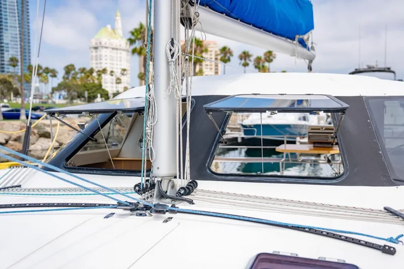 Making Waves Yacht Photos Pics 2006 Seawind 1160 catamaran with open windows, docked near palm trees and buildings.