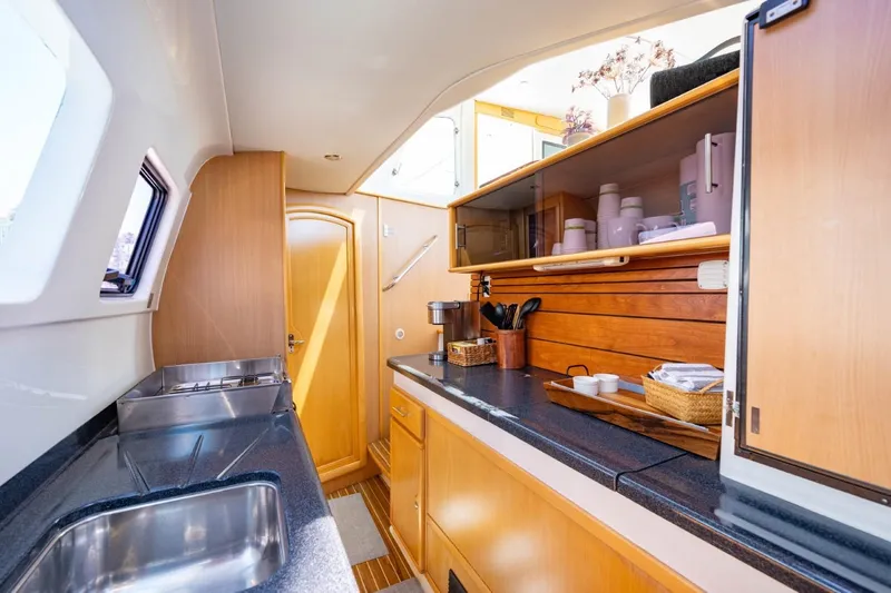 Making Waves Yacht Photos Pics Interior of 2006 Seawind 1160 catamaran kitchen with wooden cabinetry and modern amenities.
