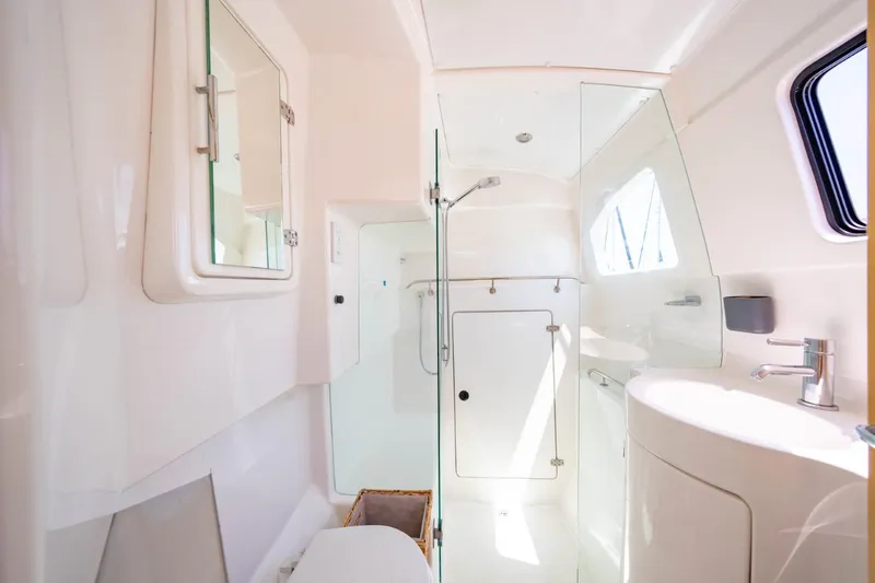 Making Waves Yacht Photos Pics 2006 Seawind 1160 yacht bathroom with shower, sink, and mirror in bright, modern design.