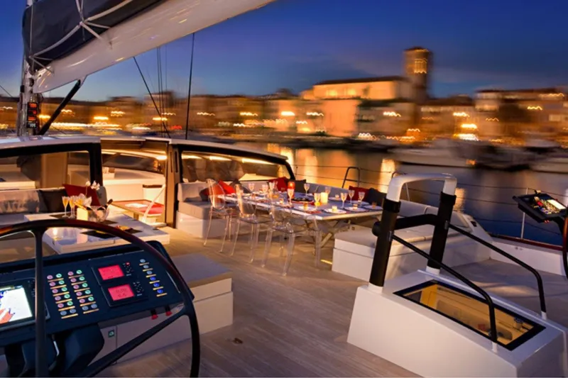 Nomad IV Yacht Photos Pics Luxurious 2013 Maxi Dolphin Cruiser-Racer yacht deck at sunset, featuring elegant dining setup.