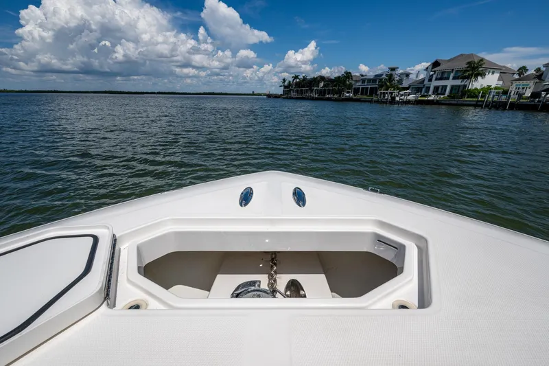  Yacht Photos Pics Bow view of 2015 Invincible 42 Open Fisherman on calm waters near waterfront homes.
