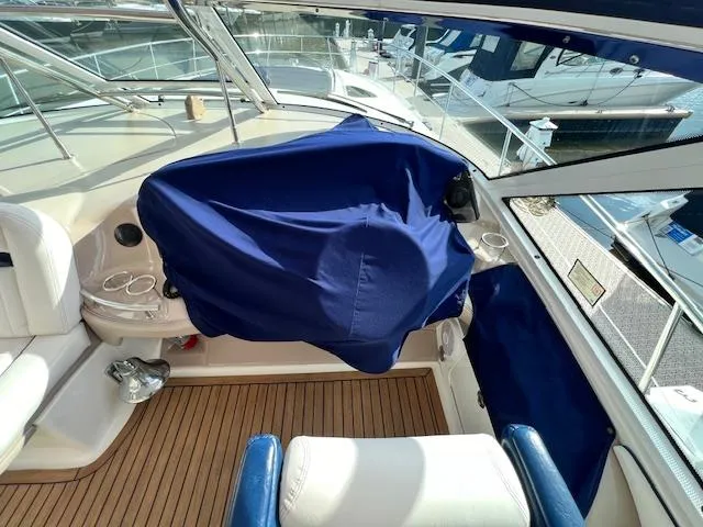  Yacht Photos Pics 2005 Sea Ray 500 Sundancer cockpit with blue cover, featuring teak flooring and white seating.
