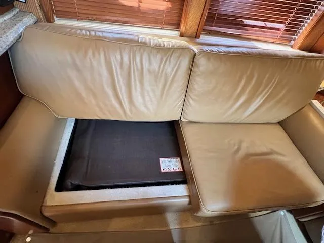  Yacht Photos Pics 2005 Sea Ray 500 Sundancer interior with beige leather seating and hidden storage compartment.