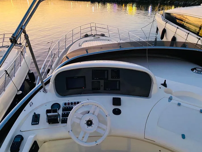  Yacht Photos Pics Cockpit view of 2006 Azimut 68 yacht at sunset, docked beside other boats.