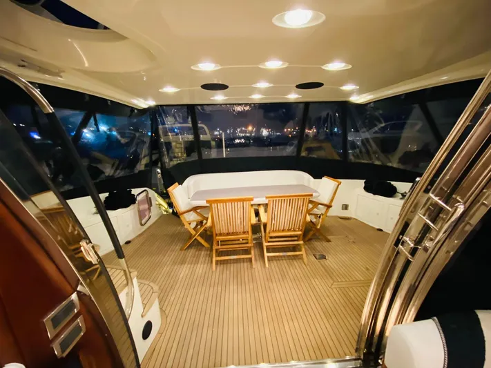  Yacht Photos Pics Luxurious 2006 Azimut 68 yacht interior with wooden deck and seating area at night.