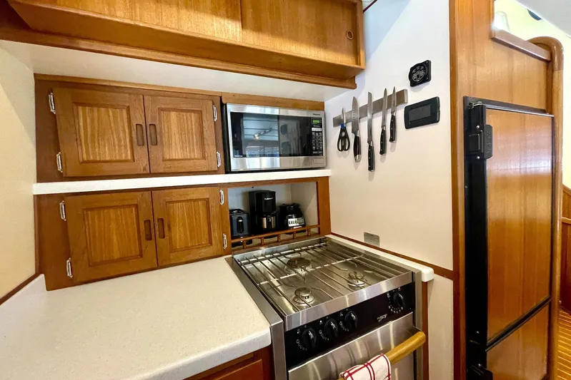 Slainte II Yacht Photos Pics Galley kitchen in 2008 Nordic Tug 42 with stove, microwave, and wooden cabinetry.