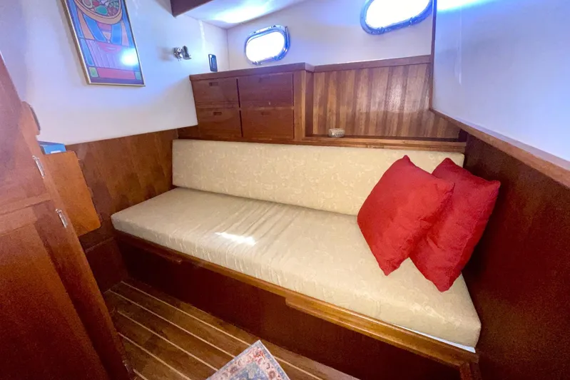 Slainte II Yacht Photos Pics Cozy cabin interior of 2008 Nordic Tug 42 with wooden finish and red cushions.