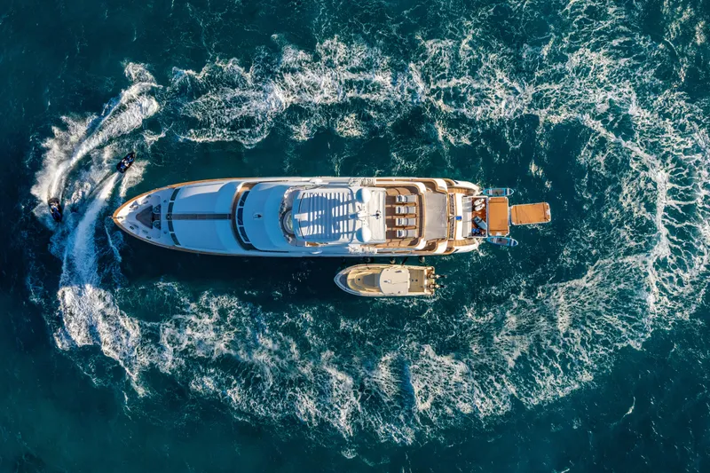 Allora Yacht Photos Pics Aerial view of 2011 Benetti Classic 121 yacht with jet skis in ocean.