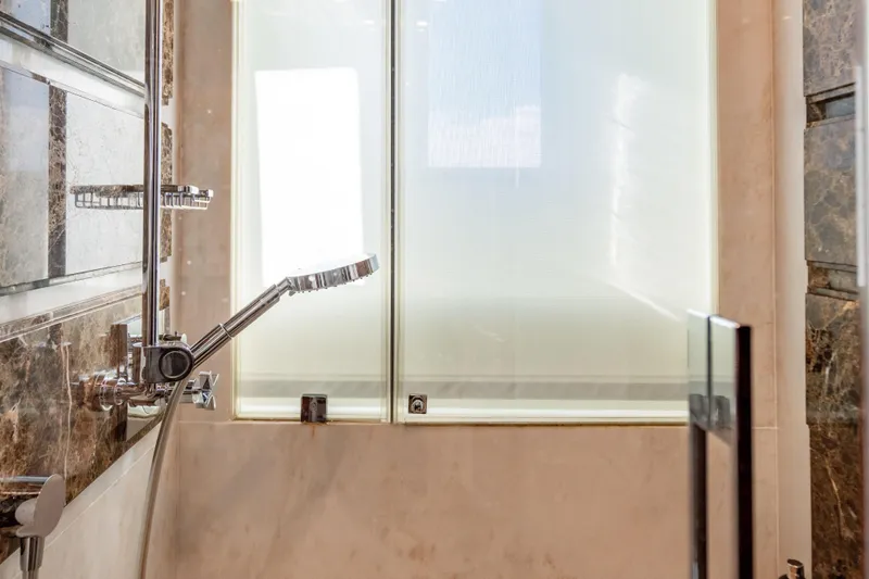 Allora Yacht Photos Pics Luxurious bathroom shower in 2011 Benetti Classic 121 yacht, featuring marble and chrome fixtures.