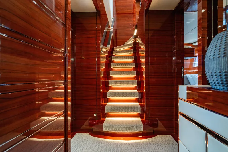 Allora Yacht Photos Pics Luxurious interior of 2011 Benetti Classic 121 yacht with illuminated wooden staircase.