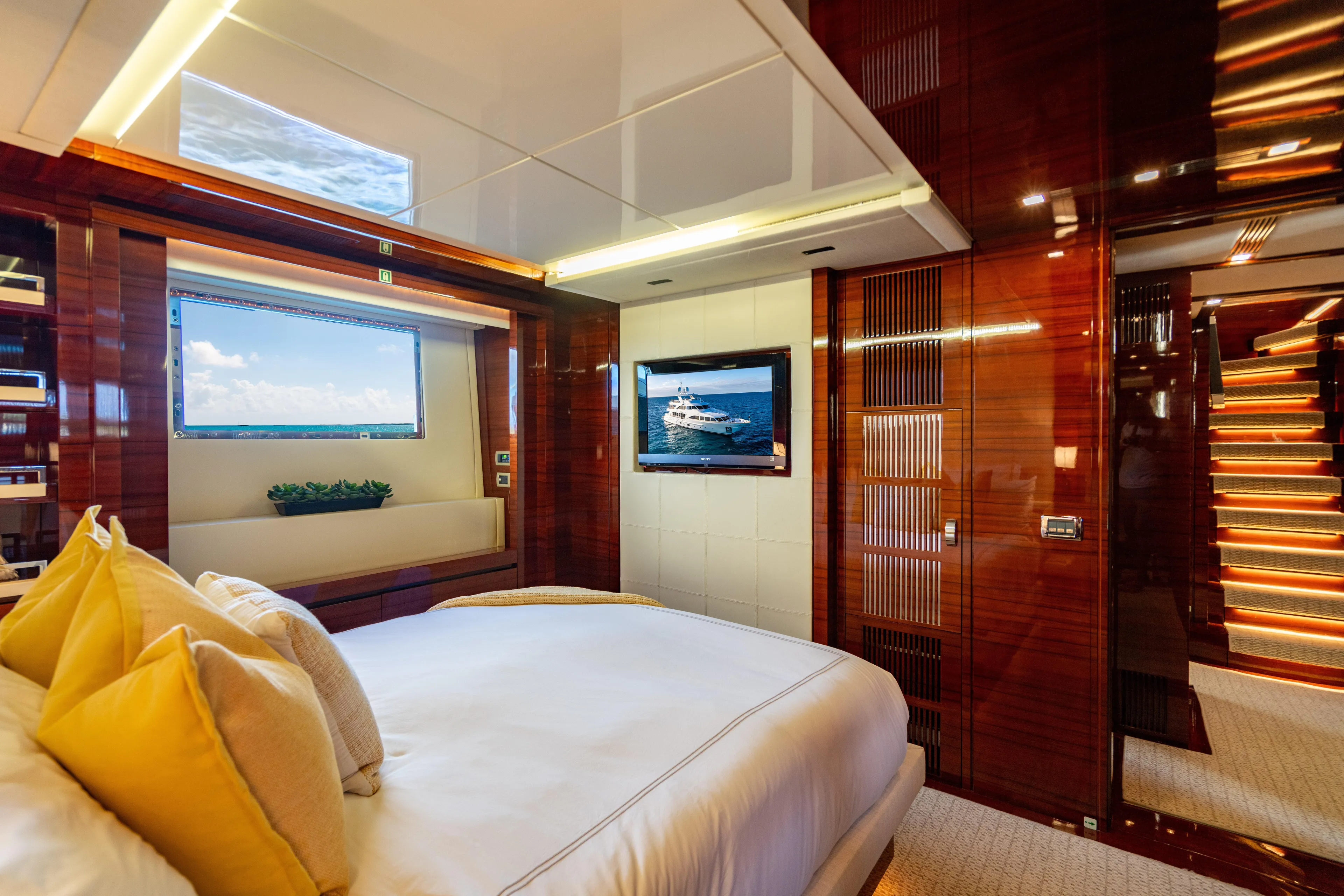 Allora Yacht Photos Pics Luxurious bedroom interior on 2011 Benetti Classic 121 yacht, featuring elegant wood finishes and modern decor.