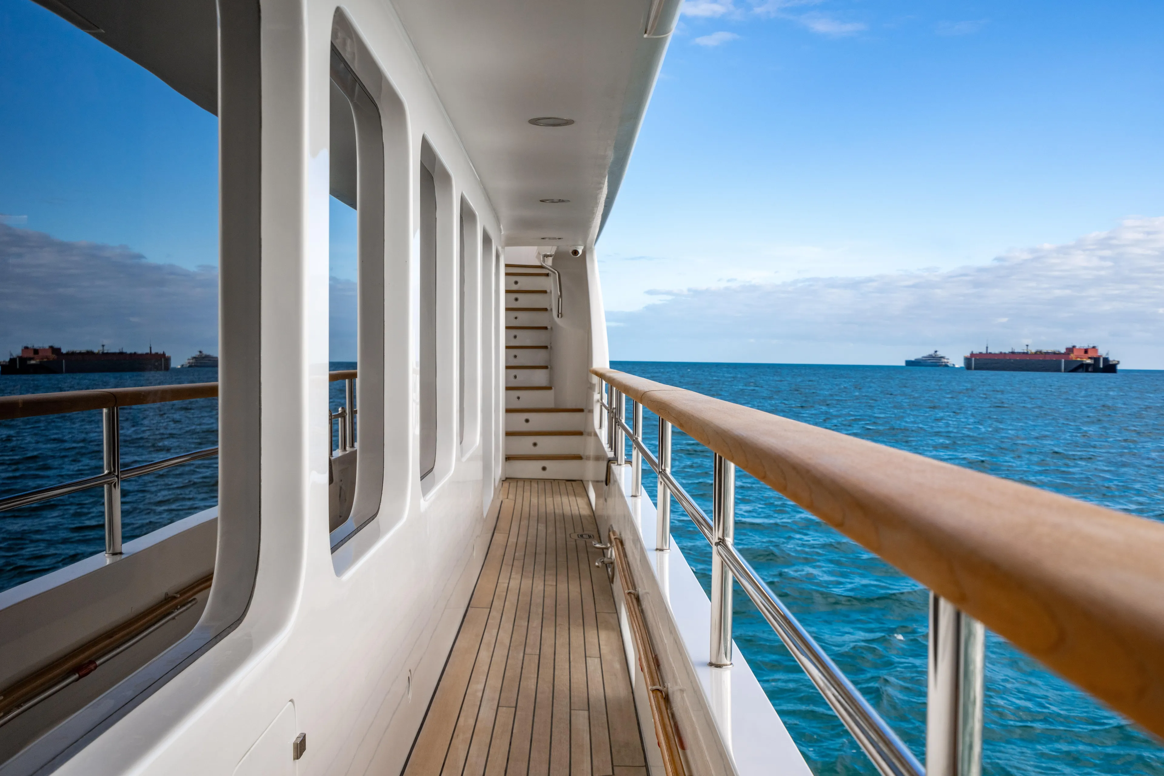 Allora Yacht Photos Pics Side deck of 2011 Benetti Classic 121 yacht with ocean view and distant ships.