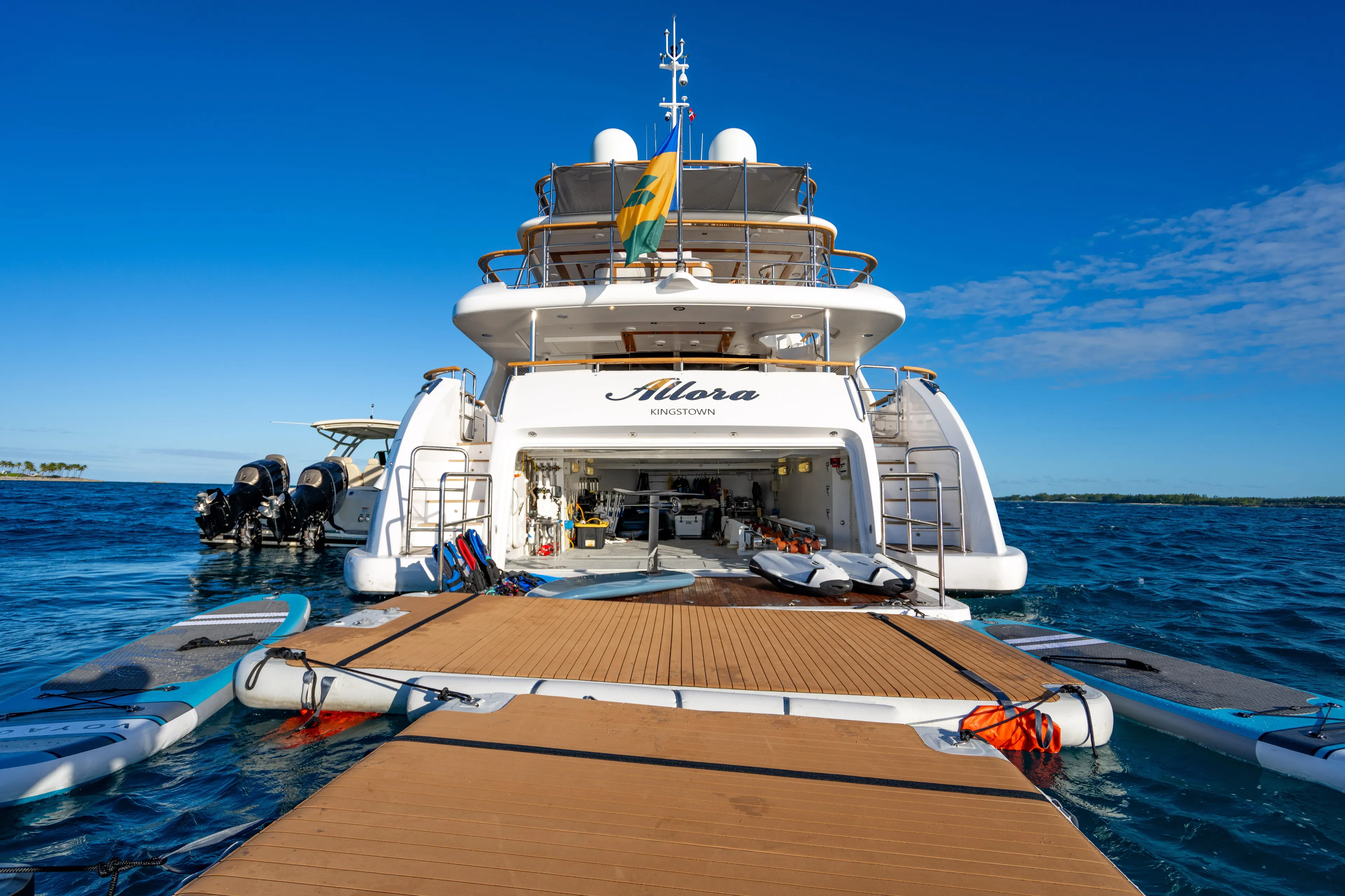 Allora Yacht Photos Pics Luxury Benetti Classic 121 yacht, 2011 model, docked with paddleboards and clear blue skies.