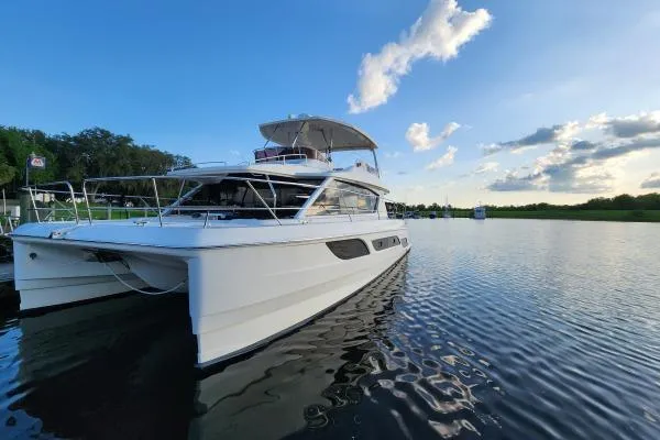 Kimberly Dawn Yacht Photos Pics Aquila 48 PC 2014 yacht on serene water under a blue sky.
