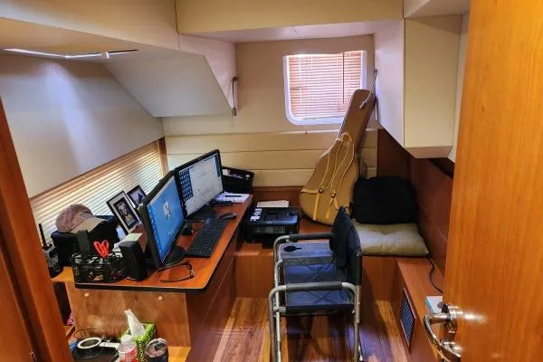 Kimberly Dawn Yacht Photos Pics Office space inside 2014 Aquila 48 PC yacht with desk, monitors, and guitar case.