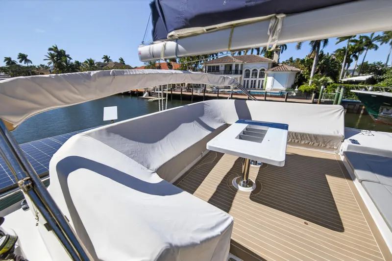  Yacht Photos Pics Leopard 50 yacht deck with seating and table, docked by waterfront homes, 2021 model.